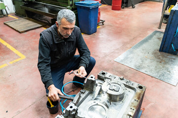Lathe worker man working with a vernier and milling machine in a factory, using a caliper to check measurement.