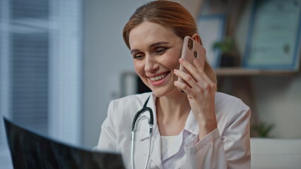Fototapeta premium Professional reviewing medical scan on call closeup. Joyful therapist in clinic