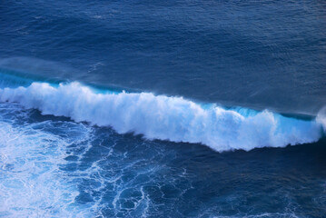 Turquoise ocean sea water white wave pattern splashing deep blue sea. Seascape dark ocean background wave splash on rock. Tropical sea beach in summer seaside outdoor. Water Surface blue wave pattern