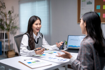 Two businesswomen having a productive meeting discussing charts and business reports