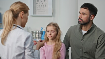 Ill girl visiting clinic doctor with parent closeup. Pediatrician measuring body