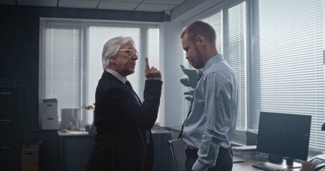 In modern office of bank: Irritated and angry boss having fight with male company employee over...