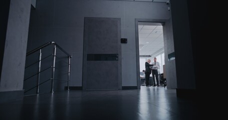 Fototapeta premium Business process in modern investment company's office: Analyst reports to manager on the stock market's price growth and investment results. Female manager goes to meeting room with documents.