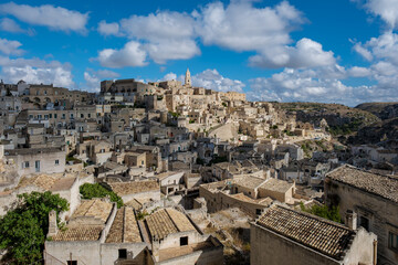 Obraz premium Stunning panorama of Matera, Puglia, showcasing ancient stone architecture and vibrant skies