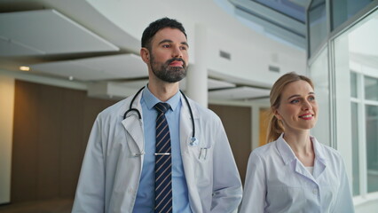Smiling doctors walk together in modern clinic. Closeup Healthcare professionals