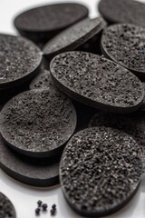 Activated carbon in the form of tablets, on a light background.