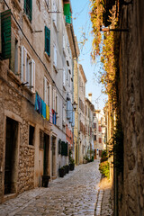 Charming cobblestone alley in Rovinj, Croatia with vibrant laundry and soft evening light
