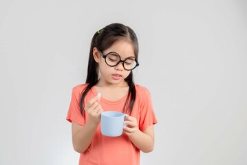 asia cute girl taking pill on white background.