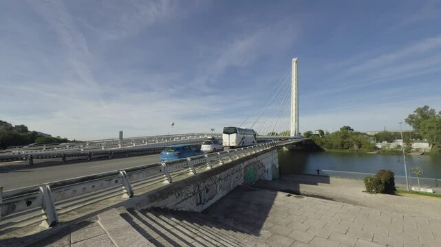 vista del puente del alamillo desde el laterial, mientras cruzan vehiculos hacia las afueras de la ciudad