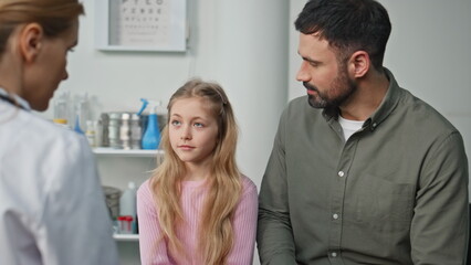 Fototapeta premium Sick girl talking pediatrician in clinic closeup. Ill kid describing symptoms