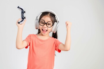 Asian happy portrait young kid girl smile lifestyle games technology holding joystick game playing...
