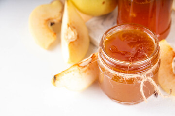 Apple quince jam. Sweet autumn homemade quince jam or marmalade canning preserves in a jar, with whole and cut apple quinces c in the background