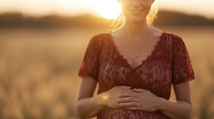 A glowing pregnant woman stands in a field at sunset, cradling her baby bump, radiating happiness and anticipation.