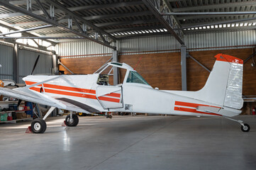 Small private lightweight propeller airplane in hangar, closeup photo