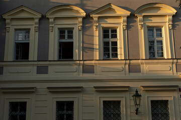 An elegantly designed facade showcases classic windows and intricate details, softly illuminated by gentle light