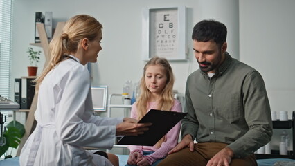 Doctor discussing kid health in clinic room closeup. Happy father talking girl