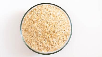Oat flakes pile, cereal for breakfast isolated on white, top view