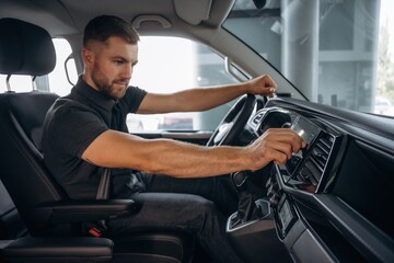 View from the side. Man is sitting in the car, driver