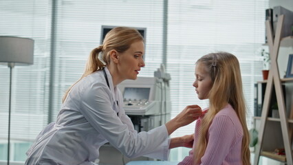 Professional practitioner talking child in clinic closeup. Sick girl visiting