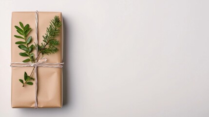 A beautifully wrapped gift in simple kraft paper, adorned with twine and fresh greenery, creating an elegant and natural presentation.