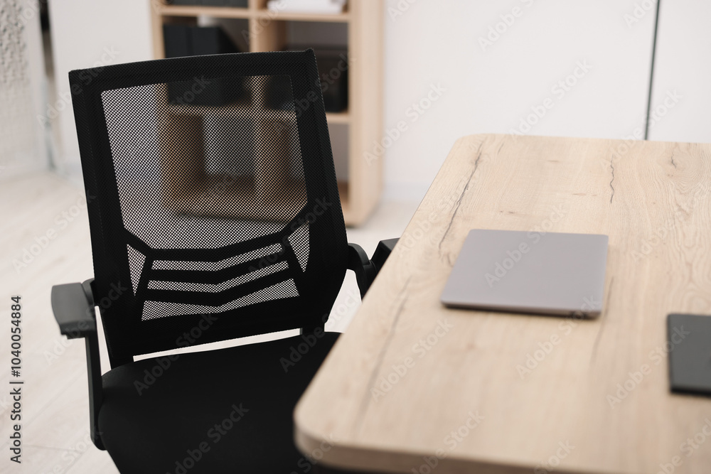 Poster Black chair, laptop and desk in office, closeup