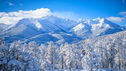 Fototapeta premium Snow-covered mountain views, with towering peaks beneath a clear blue sky, create a winter scene.