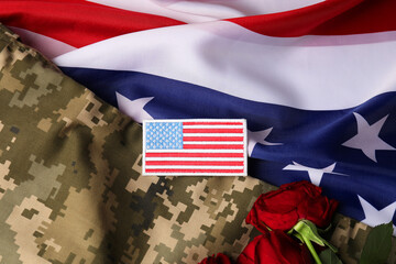 Veterans day. USA army patch, rose flowers and military uniform on American flag, flat lay