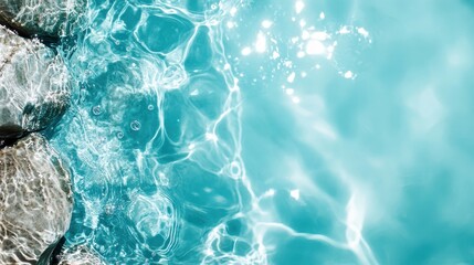 Naklejka premium A close-up capture of pristine water with shimmering reflections, bordered by smooth rocks, showcasing a tranquil and naturally calming environment.