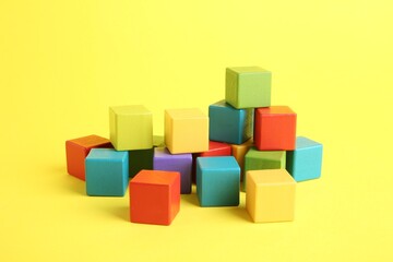 Obraz premium Many wooden colorful cubes on yellow background