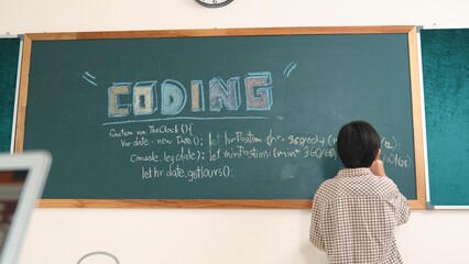 Energetic elementary student standing blackboard while writing coding engineering prompt and...