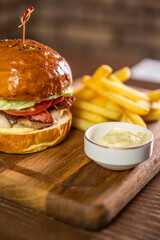 A classic burger served with a side of fries and dipping sauce, showcasing a delicious and...