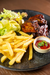 Juicy ribs served with crispy fries, sauce, and fresh salad leaves. Perfect for themes of hearty...