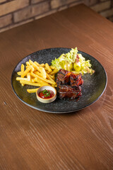 Juicy ribs served with crispy fries, sauce, and fresh salad leaves. Perfect for themes of hearty...