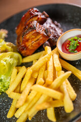 Juicy ribs served with crispy fries, sauce, and fresh salad leaves. Perfect for themes of hearty meals, comfort food, and restaurant dining experiences