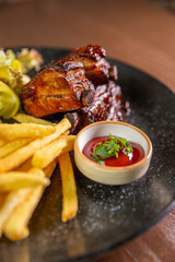 Juicy ribs served with crispy fries, sauce, and fresh salad leaves. Perfect for themes of hearty...