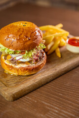 A classic burger served with a side of fries and dipping sauce, showcasing a delicious and indulgent meal. Perfect for themes of fast food, casual dining, and comfort food cravings