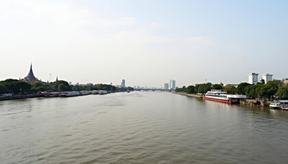Fototapeta premium Calm waters of a city river with boats and buildings in the distance
