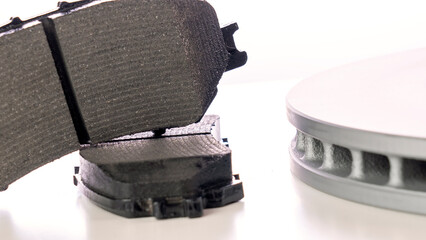 A brake pad is shown with a picture of a wheel on the side. The brake pad is black and the wheel is...