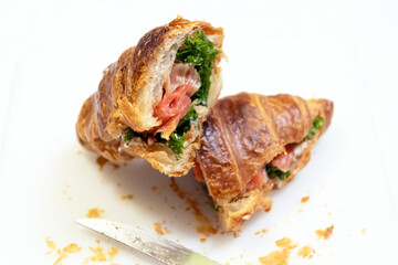 Delicious croissant filled with fresh vegetables and smoked salmon, perfect for a light snack or gourmet brunch.
