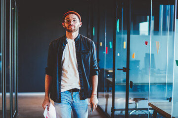 Confident casually dressed businessman walking in modern interior office thoughtfully ,serious...