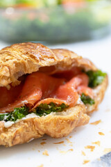 A close-up view of a delicious croissant filled with smoked salmon and fresh greens, perfect for gourmet breakfast ideas.
