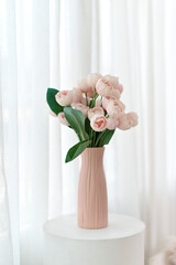 beautiful arrangement of pink flowers in textured vase, set against soft, light backdrop. delicate petals and lush green leaves create serene and elegant atmosphere