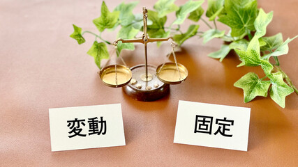 天秤と2枚のカードに変動と固定文字_茶色背景