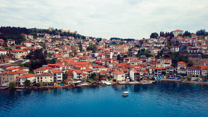 Obraz premium A picturesque view of Ohrid Macedonia showcasing charming houses along the tranquil waters of Lake Ohrid during a cloudy day