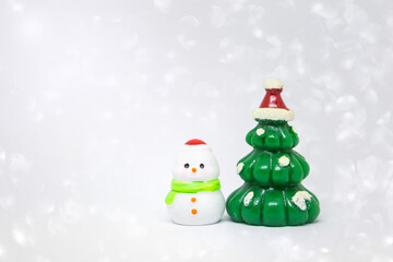 Cute little snow man with Christmas tree over blurred white bokeh background, Christmas card background idea