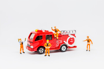 Firefighter team with fire truck isolate on white background, miniature man in safety suit with fire truck