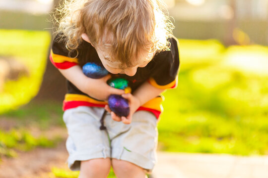 Little Aboriginal Australian boy holding foil wrapped chocolate Easter eggs