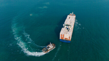 Logistics and container loading by large barges by sea in a harbor full of containers waiting to be transported.