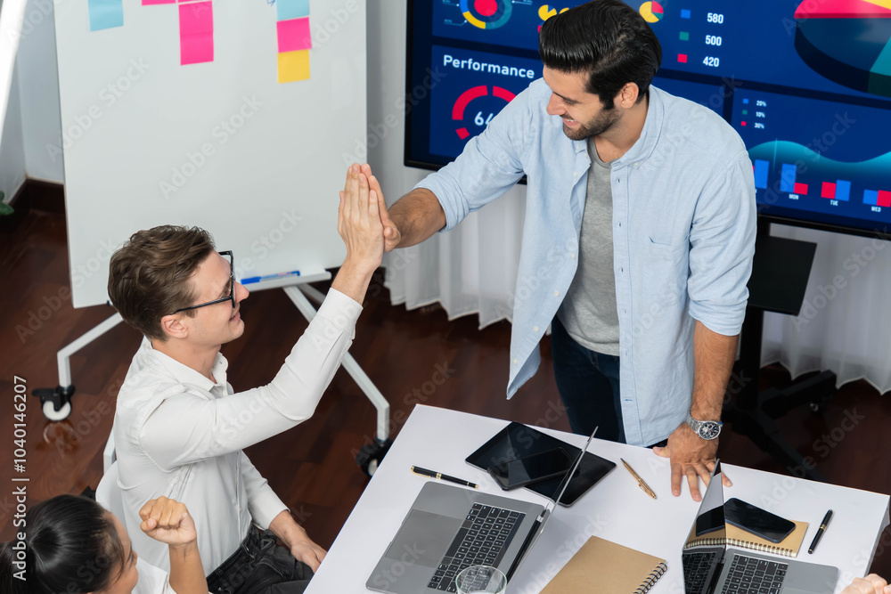 Poster Analyst team leader celebrate and high five together with his colleague after successful data analysis meeting using FIntech software power with business intelligence or BI dashboard. Prudent