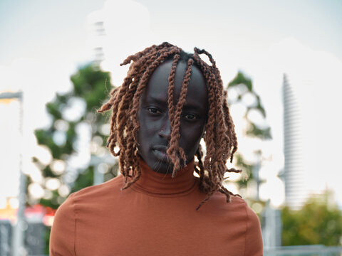 Portrait of a South Sudanese man wearing orange turtleneck